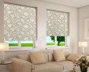 Светло-серые рулонные шторы с узорами цветов украшают окна современно дома